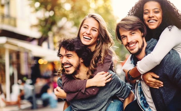 Friends enjoying each other's company, boys lifted girls on their backs, happy Valentine's day to friends