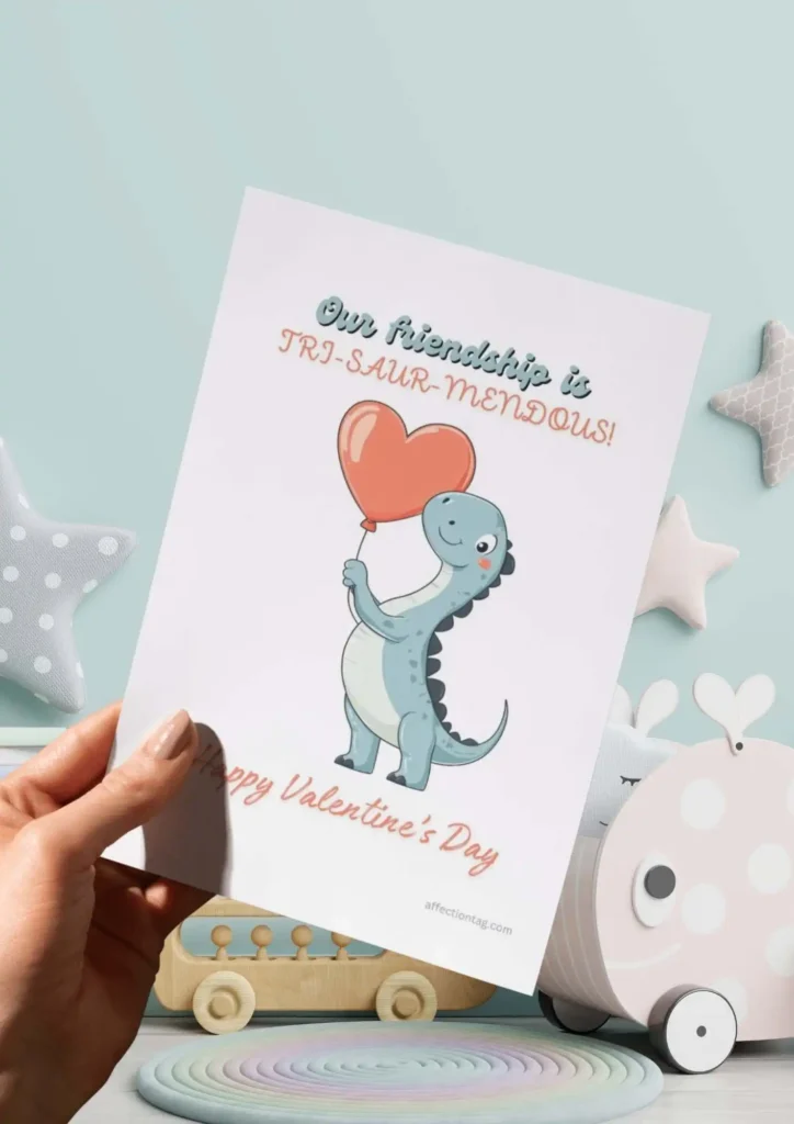 A delightful Dinosaur Valentine card featuring a smiling dinosaur holding a heart balloon, captioned "Our friendship is TRI-SAUR-MENDOUS! Happy Valentine's Day." ©affectiontag.com